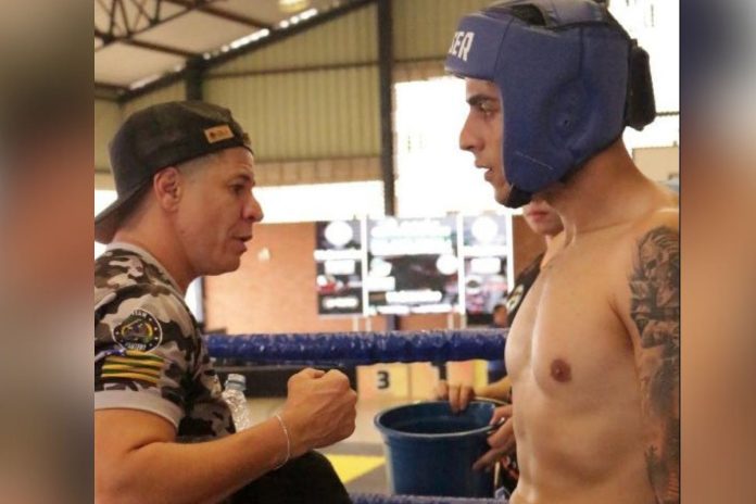 foto da atleta Jú Rocha orientando lutador de kickboxing